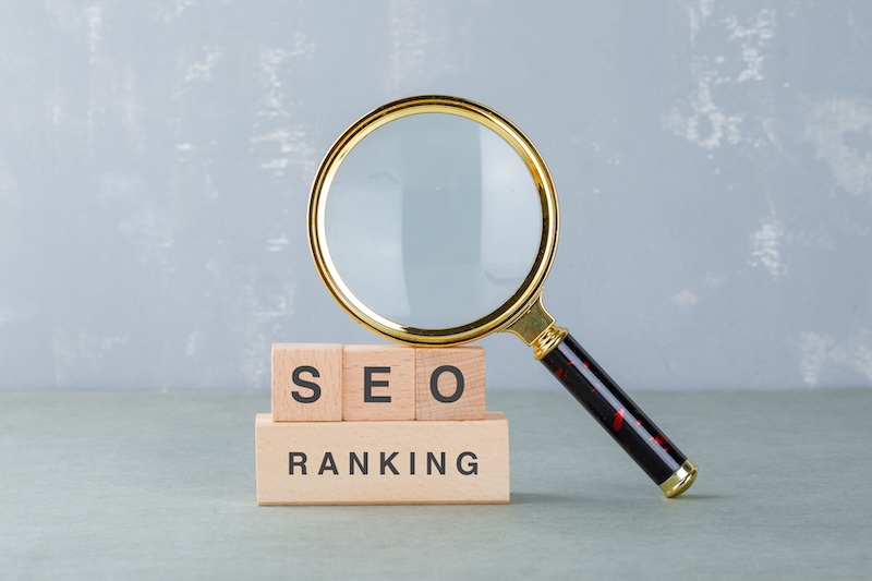 SEO RANKING i träbokstäver med en förstoringsglas